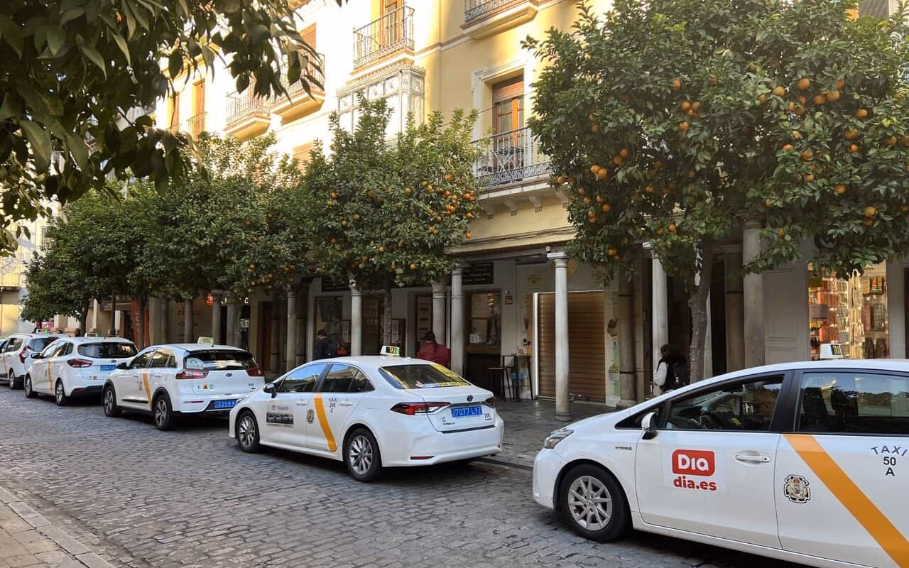 How do I stop a taxi in Seville?