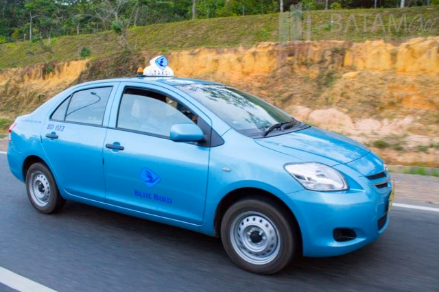 Bagaimana cara booking taksi Blue Bird dari bandara ke hotel?