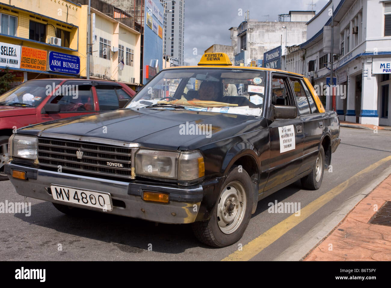 How do I stop a taxi in Malacca?